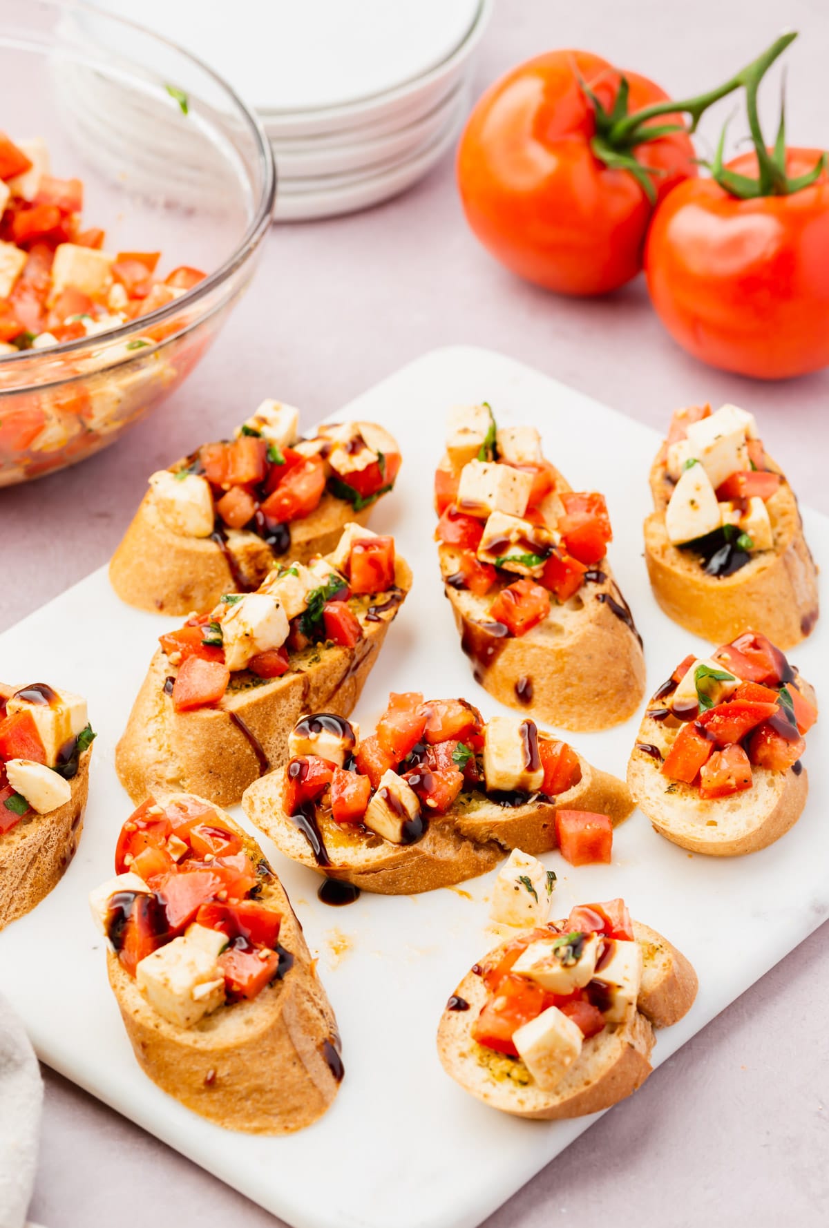 A plate full of gluten-free bruschetta with a mozzarella tomato caprese mixture topping.