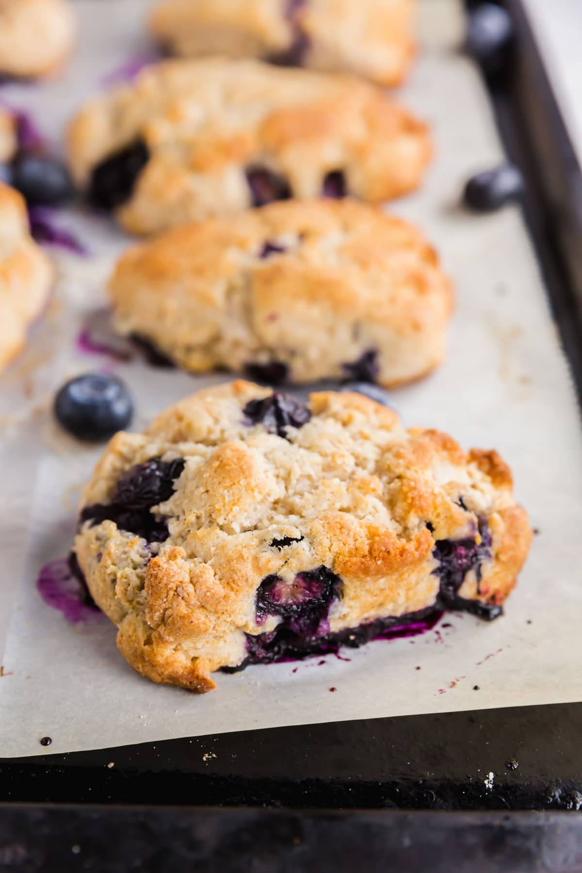 A baking sheet with gluten-free blueberry scones fresh from the oven.