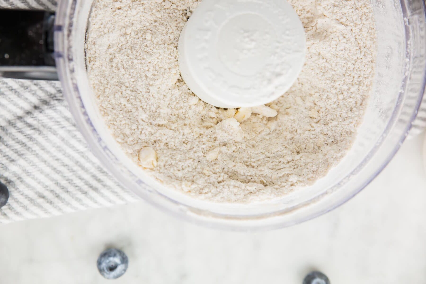 A photo of butter cut into flour mixture in a food processor.