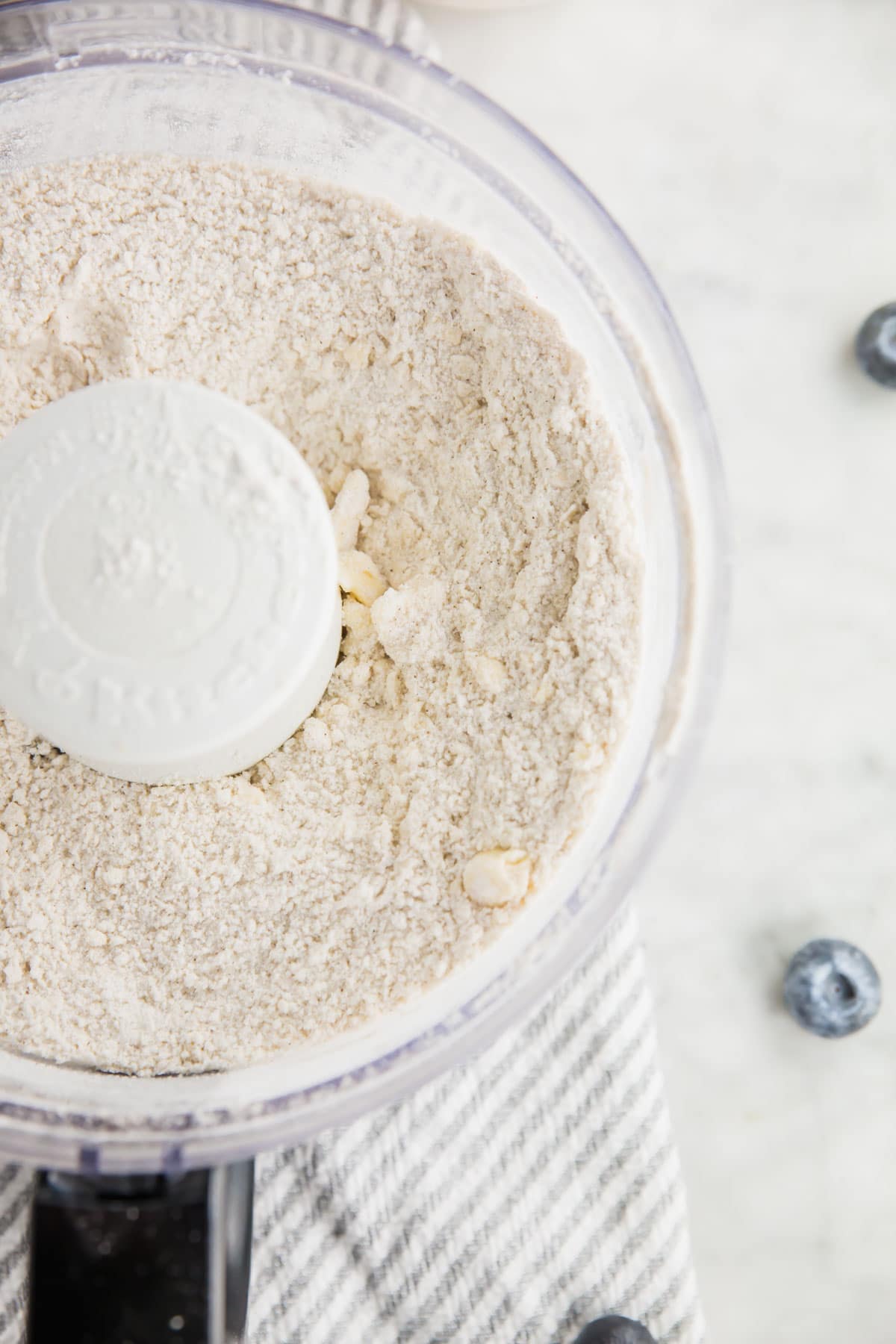 A photo of butter cut into flour mixture in a food processor. 