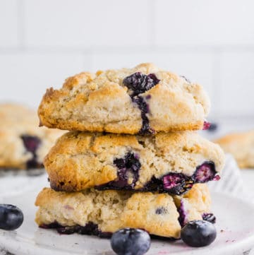 A stack of three gluten-free blueberry scones on a small plate.