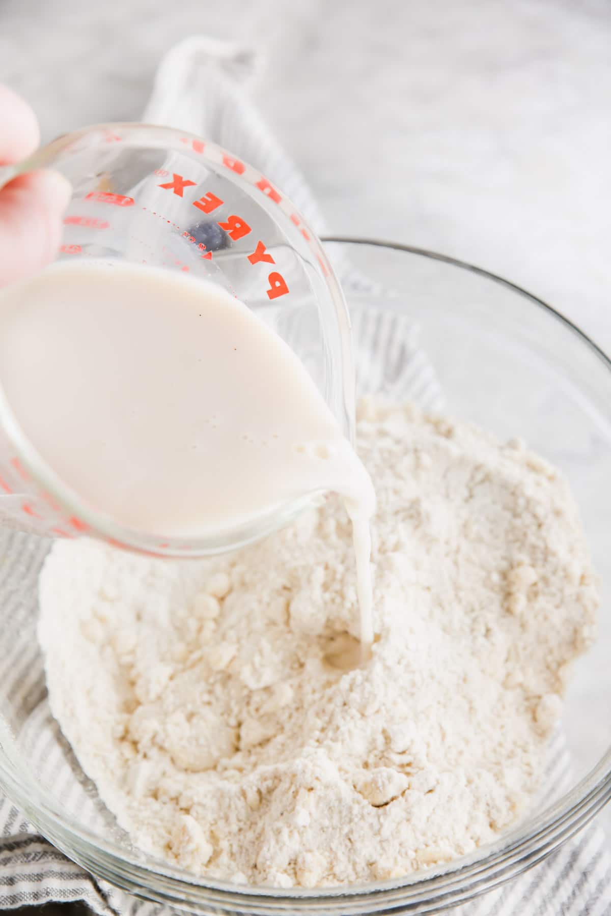 A photo of milk being poured into butter and gluten-free flour mixture. 