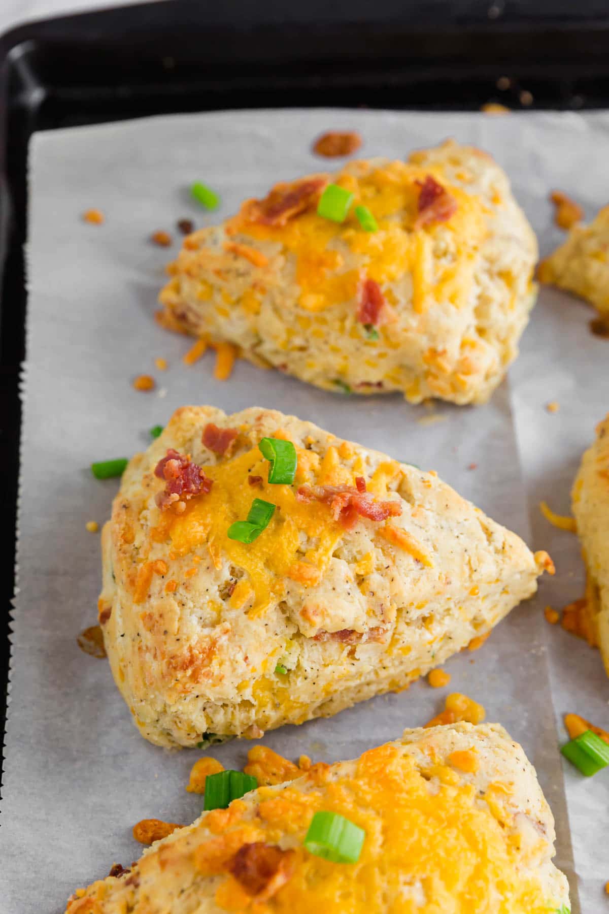 A baking sheet with fresh baked gluten-free cheddar bacon scones straight from the oven.