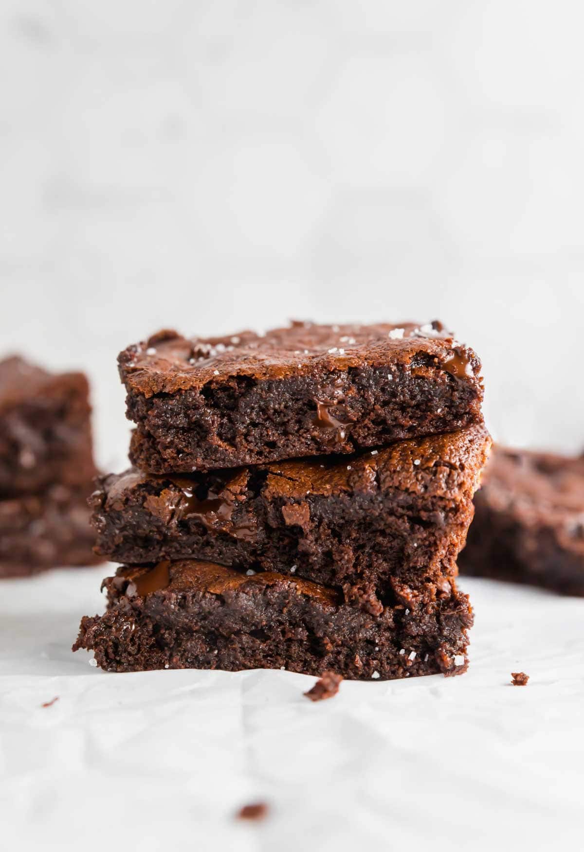 A stack of three almond flour brownies on a table.