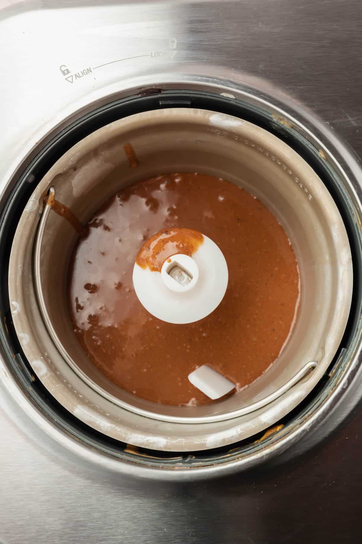 An ice cream maker with chocolate ice cream custard before churning.