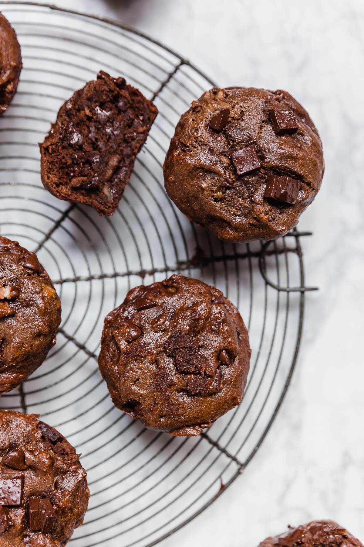 Gluten-free dairy-free vegan double chocolate chip muffins on a baking rack.