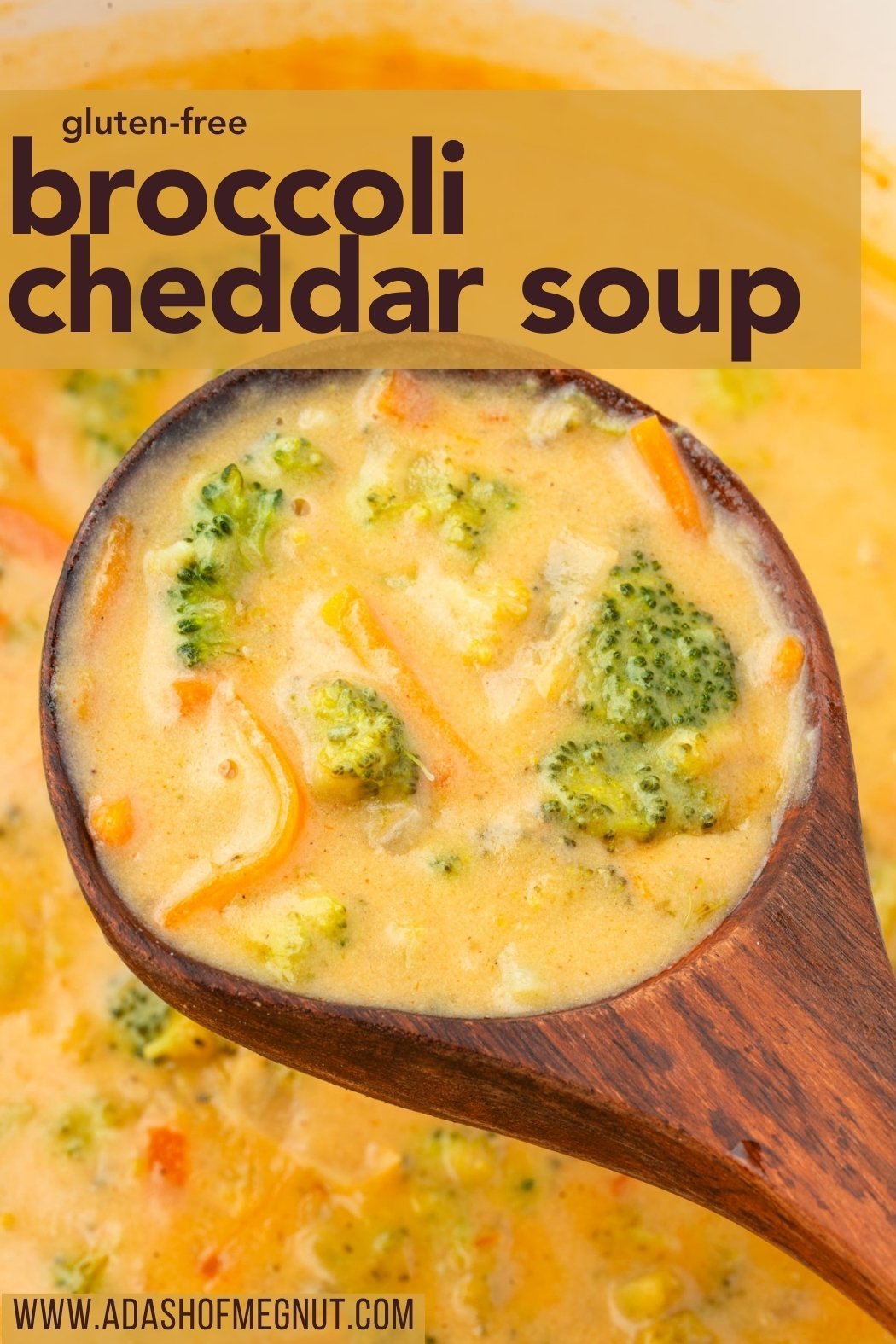 Close-up of a wooden spoon lifting a scoop of creamy broccoli cheddar soup with visible broccoli florets and carrots, over a pot of soup, with a bold text overlay for Pinterest.