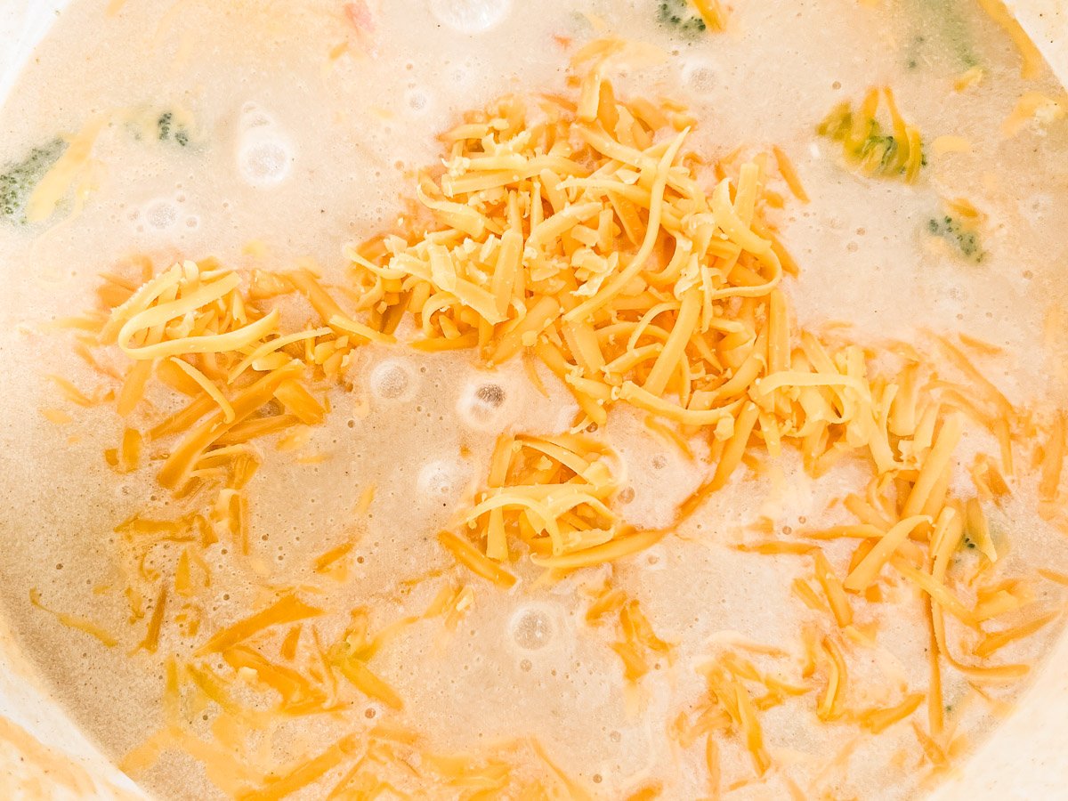 Freshly shredded cheddar cheese added into the soup, thickening the consistency.