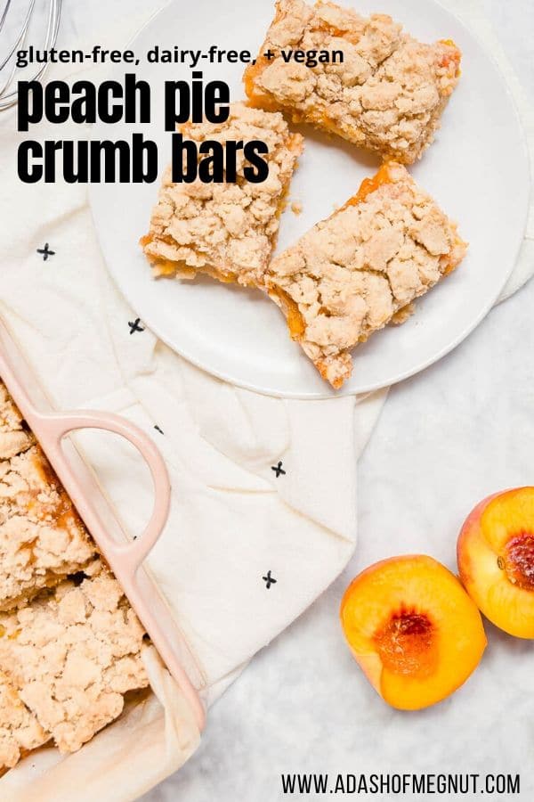 An aerial view of peach pie crumb bars on a plate with fresh peaches next to it.