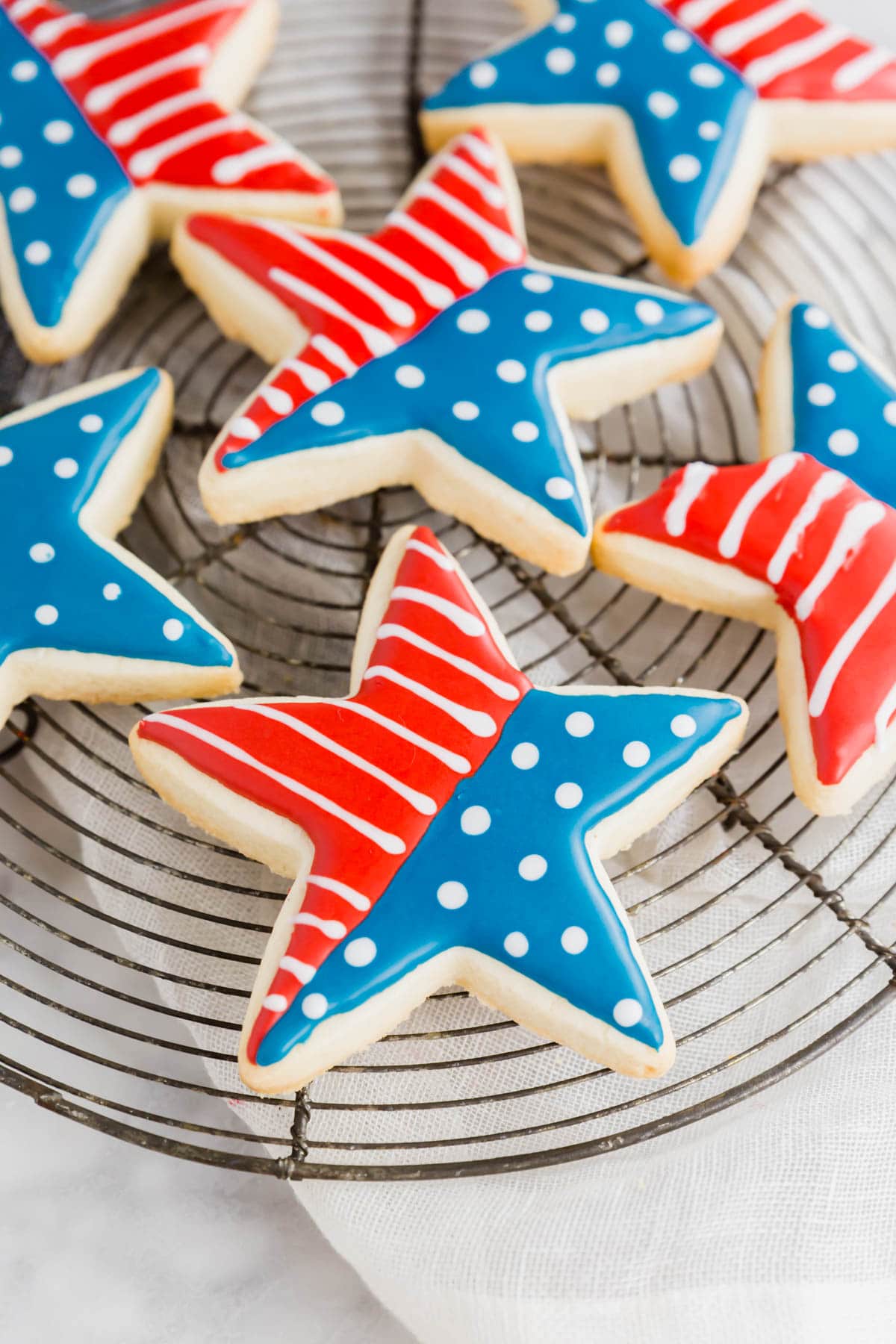 A photo of gluten-free 4th of july star sugar cookies on a cooling rack.