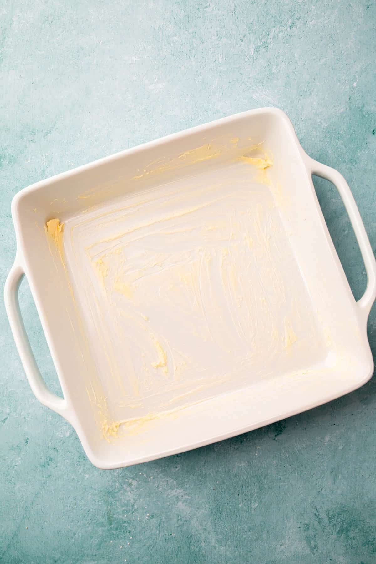 A square baking dish greased with vegan butter.