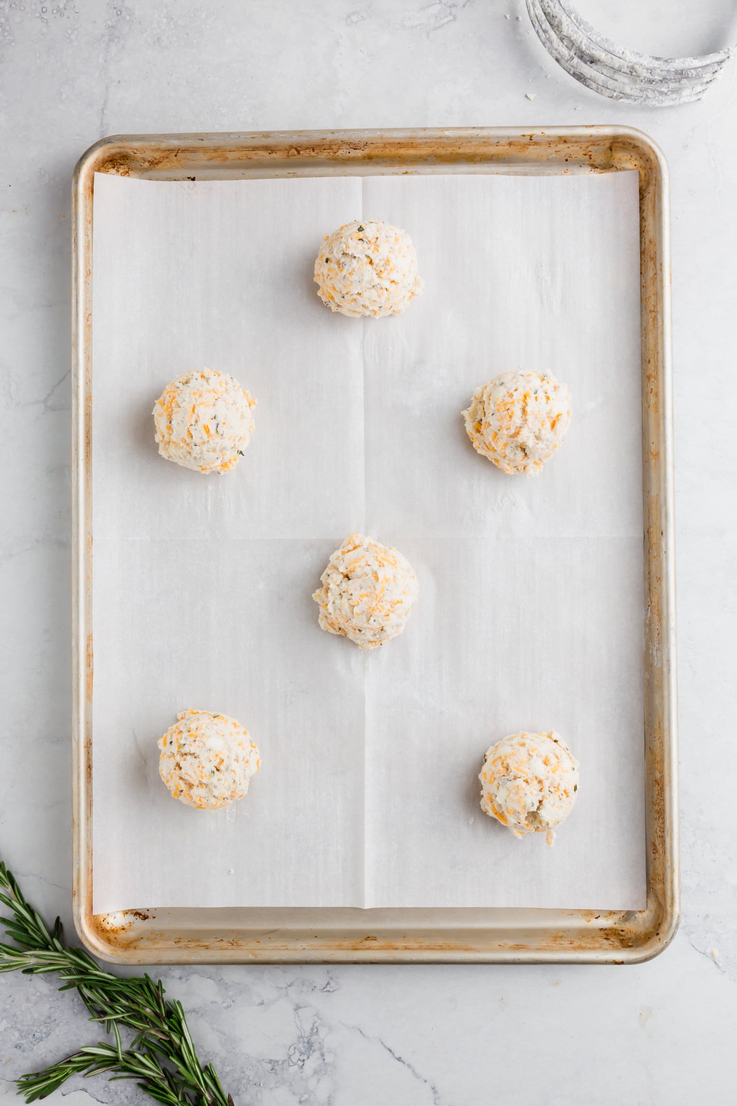 An overhead photo of gluten-free biscuit dough on a baking sheet ready to be baked.