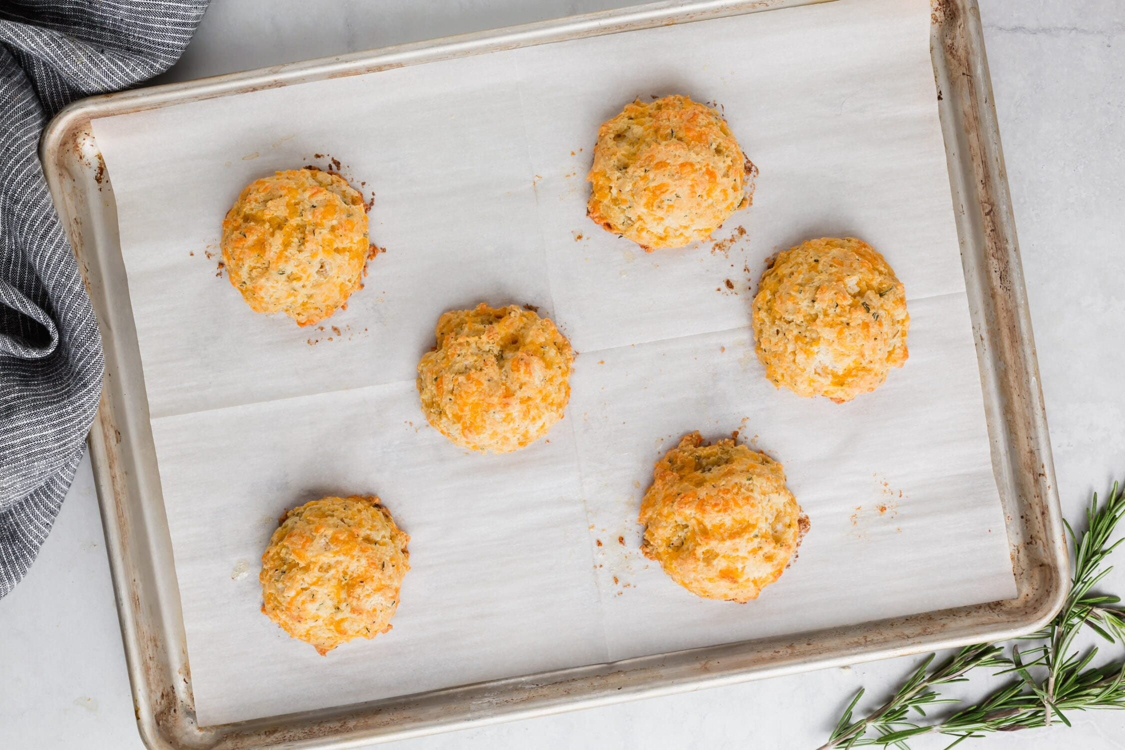 Gluten-Free cheddar biscuits baked straight out of the oven on a baking sheet.