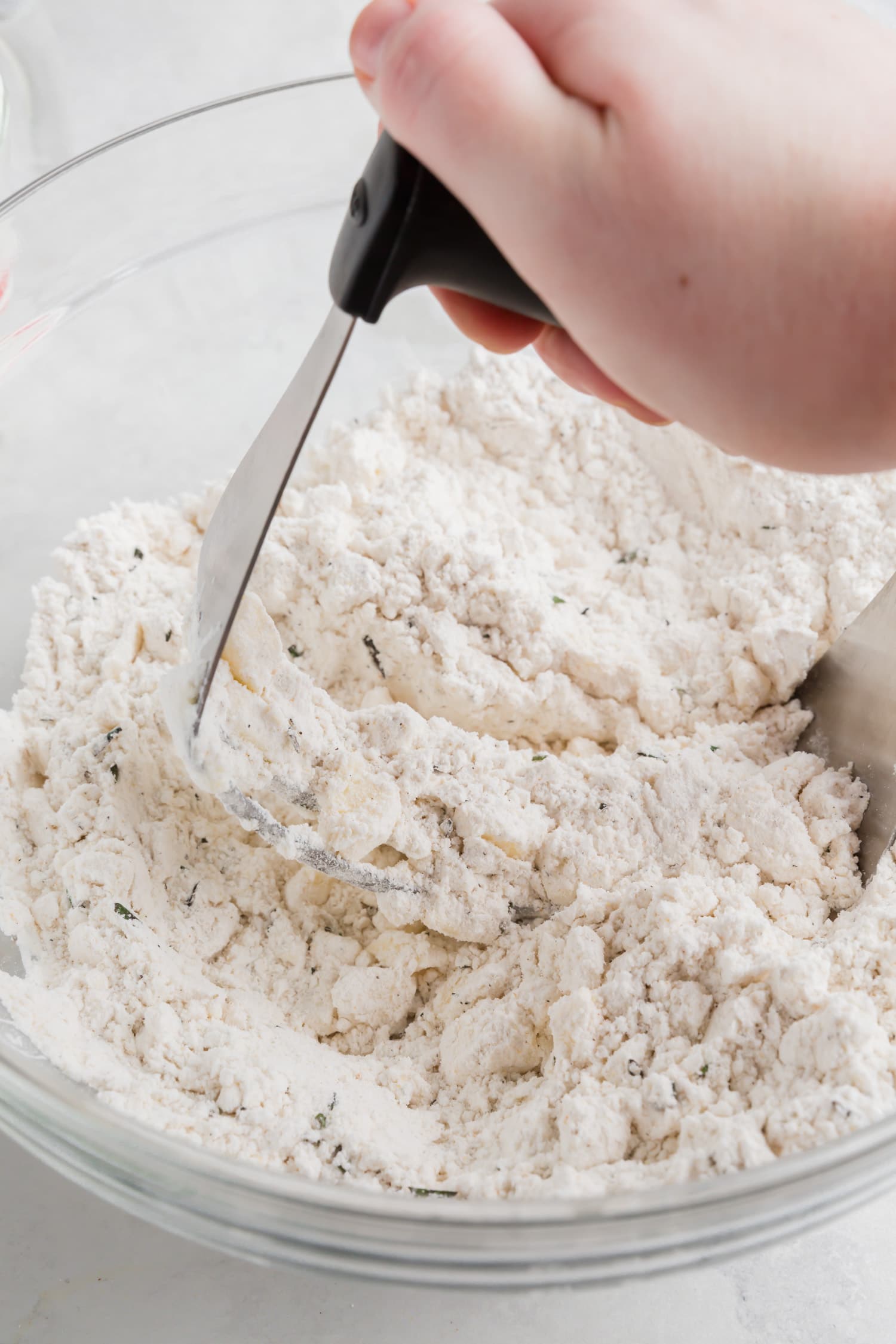 A photo of a pastry cutter cutting butter into gluten-free flour. 