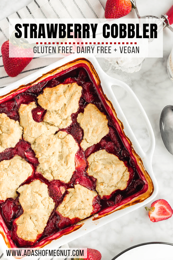 A photo of a baking sheet with strawberry cobbler topped with gluten free vegan biscuits and fresh strawberries.