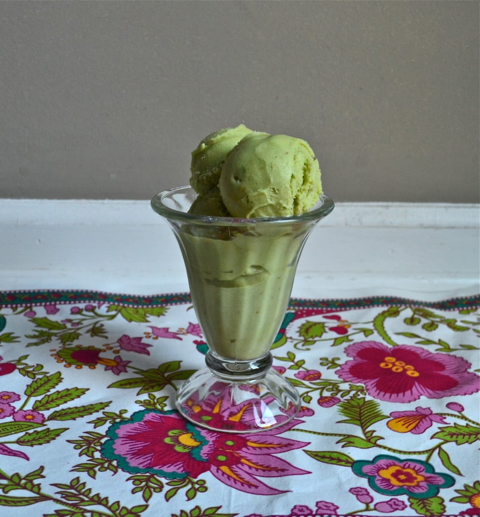 A glass bowl of avocado ice cream on a floral napkin.