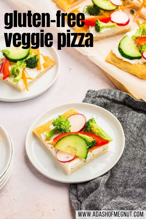 A small plate with a slice of cold veggie pizza with a full veggie pizza behind it and a gray napkin with a text overlay.