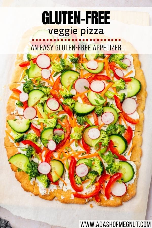 An overhead view of a full gluten-free cold veggie pizza on a piece of parchment paper with a text overlay.