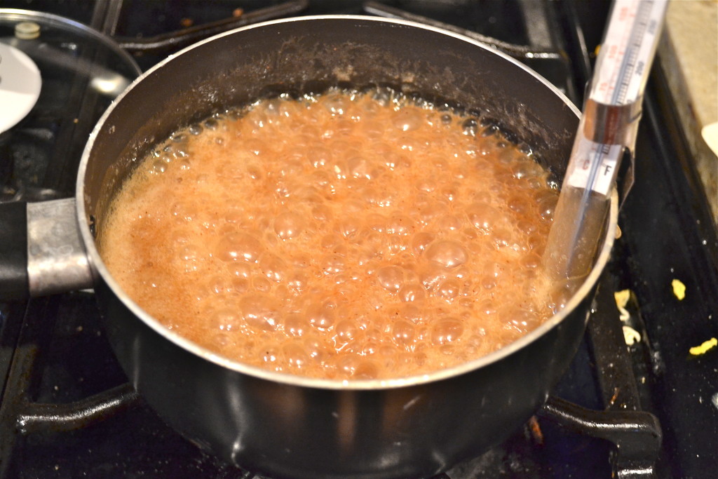 A saucepan with bubbling caramel sauce on the stovetop. 