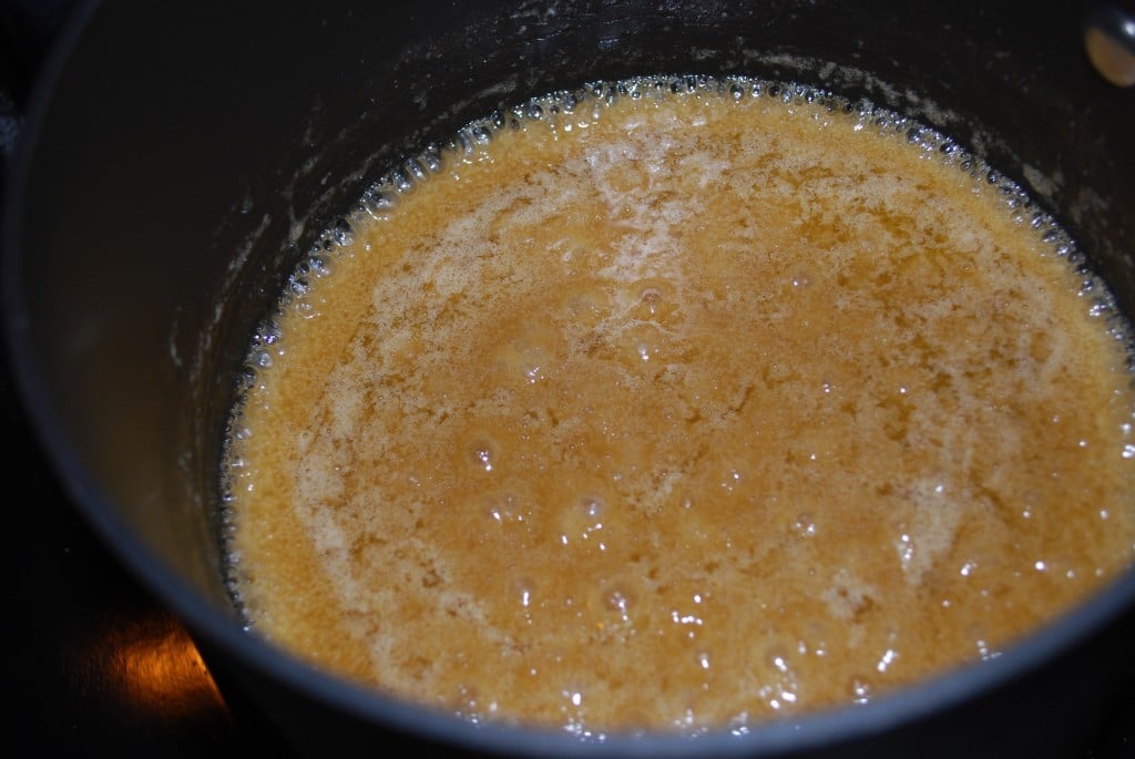 A saucepan with caramel sauce that is bubbling in it.