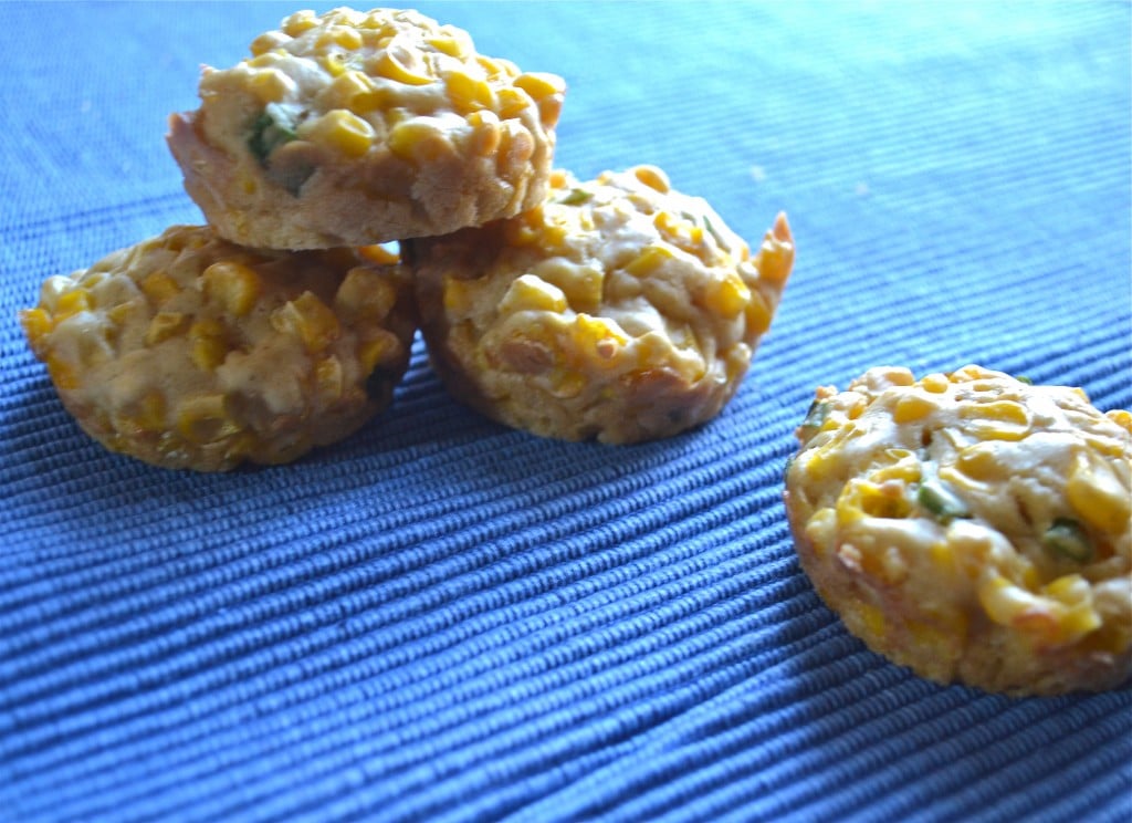 A stack of baked corn fritters on a blue placemat.