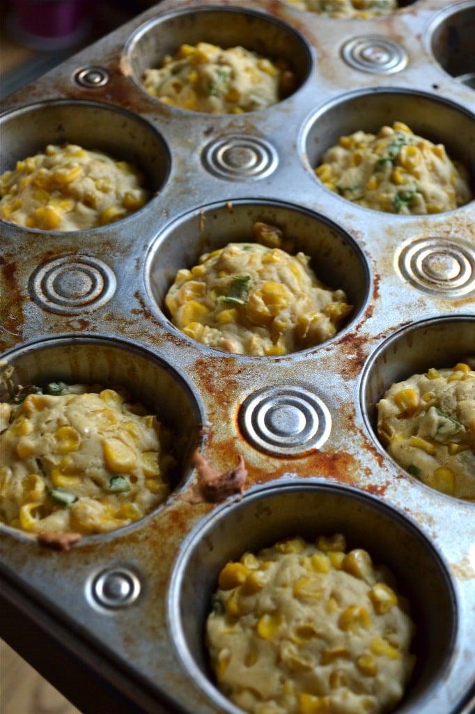 A muffin tin with baked corn fritters. 