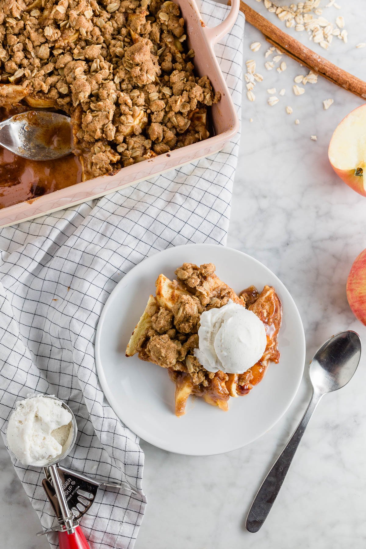 A plate with gluten-free apple crisp with a dairy-free and vegan option with a baking dish with sweet apple crisp. 