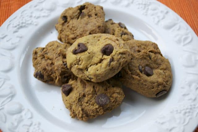 A pile of gluten-free pumpkin chocolate chip cookies on a plate.