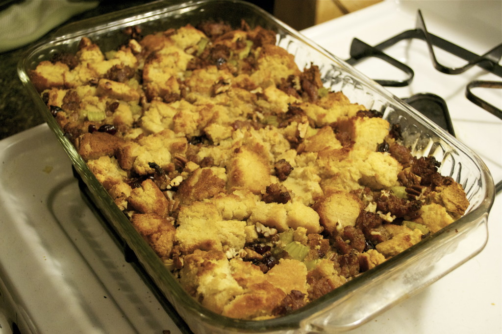 A casserole dish with cornbread stuffing and sausage.