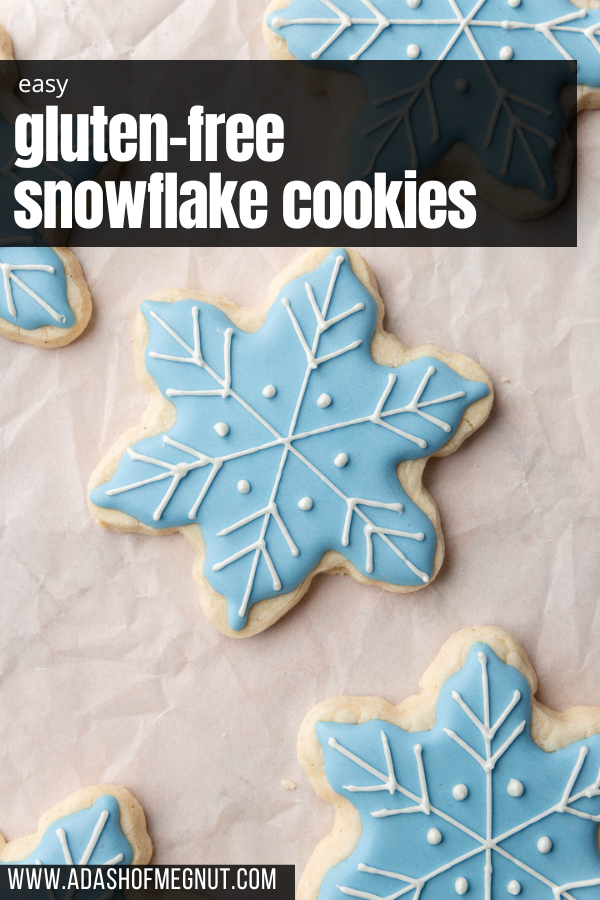 A few gluten-free snowflake sugar cookies decorated with blue royal icing and white royal icing details on top.