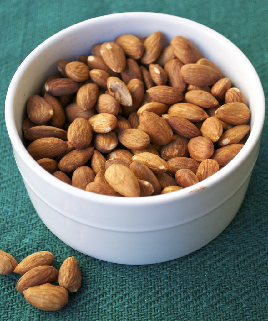 A bowl of Roasted Almonds on a green placemat.