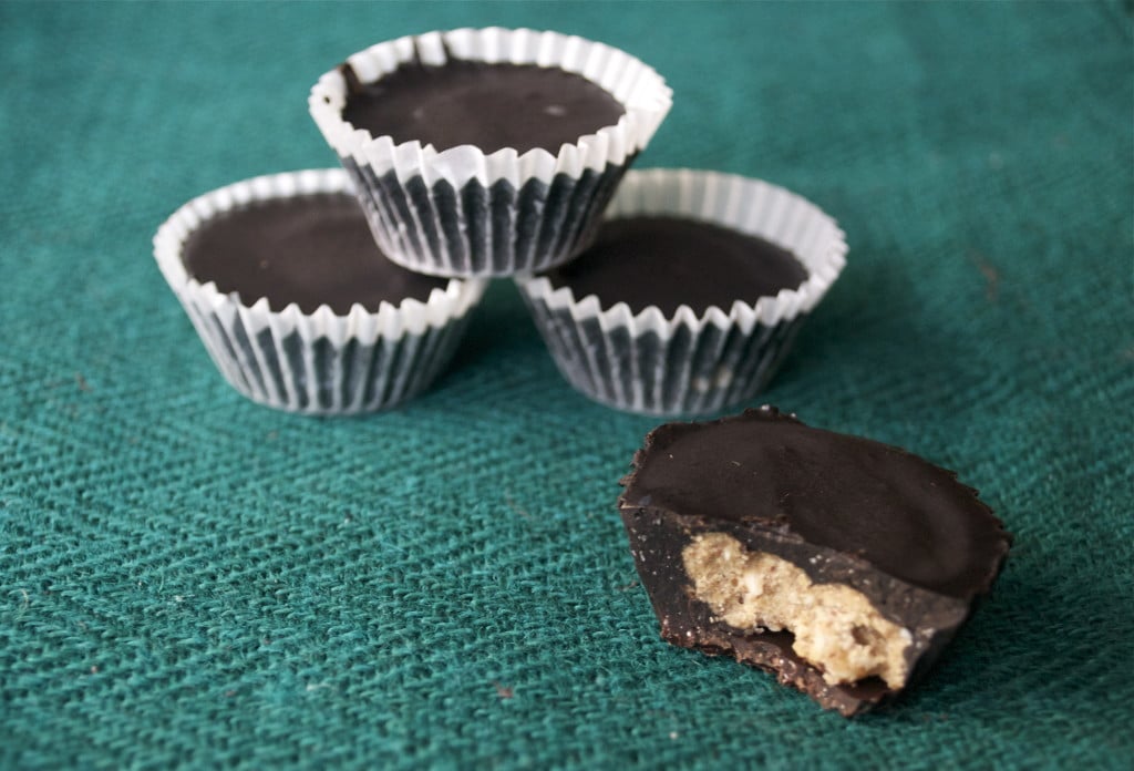 A pile of Chocolate Coconut Almond Butter Cups on a green placemat.