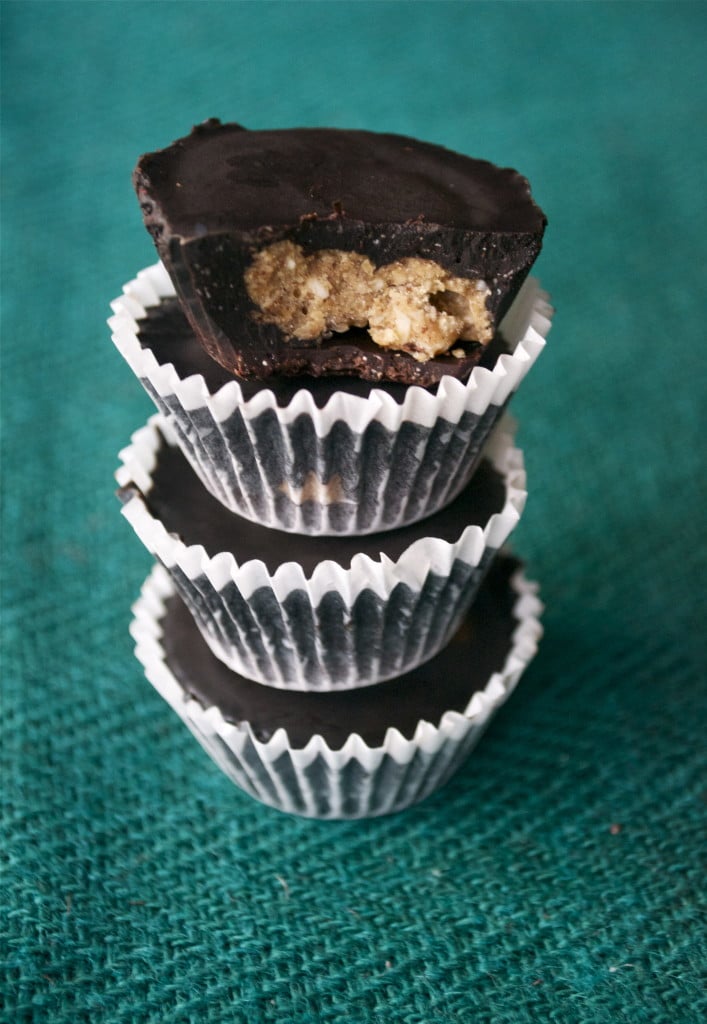 A stack of chocolate almond butter cups in paper liners.