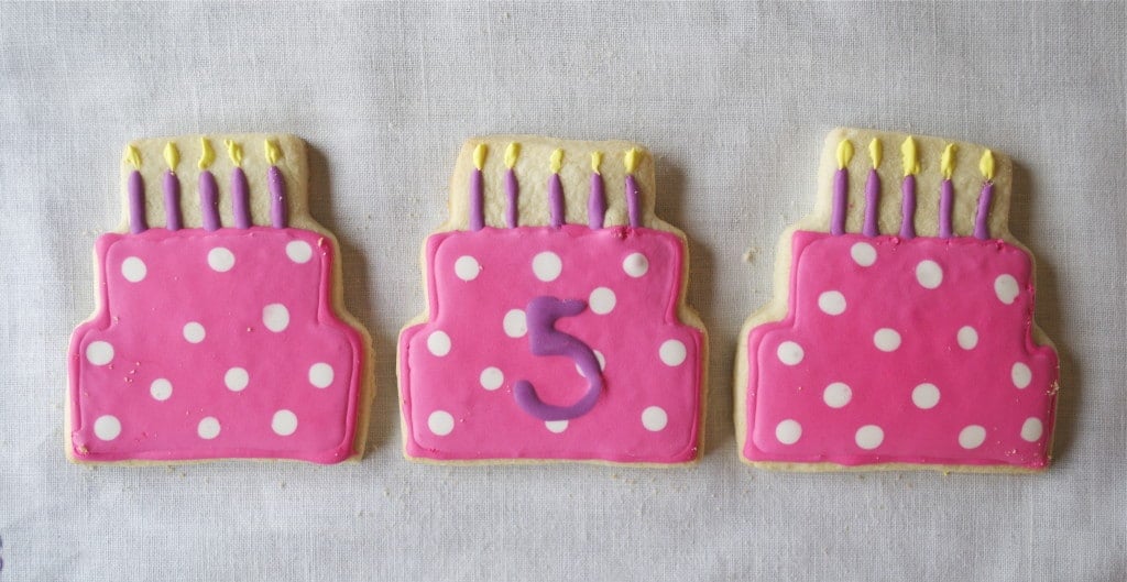 Sugar cookies decorated to look like birthday cakes with candles.