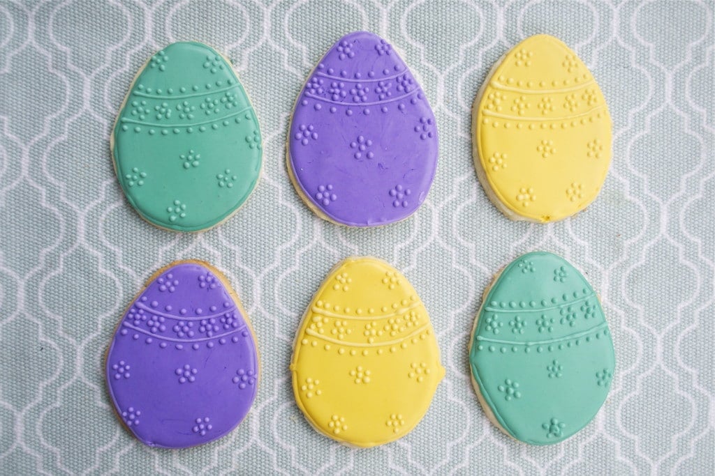 Sugar cookies decorated with green, yellow and purple royal icing to look like Easter eggs. 