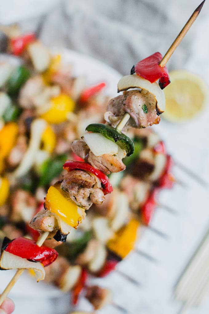 A wooden skewer alternating with chicken, bell peppers and onion. 