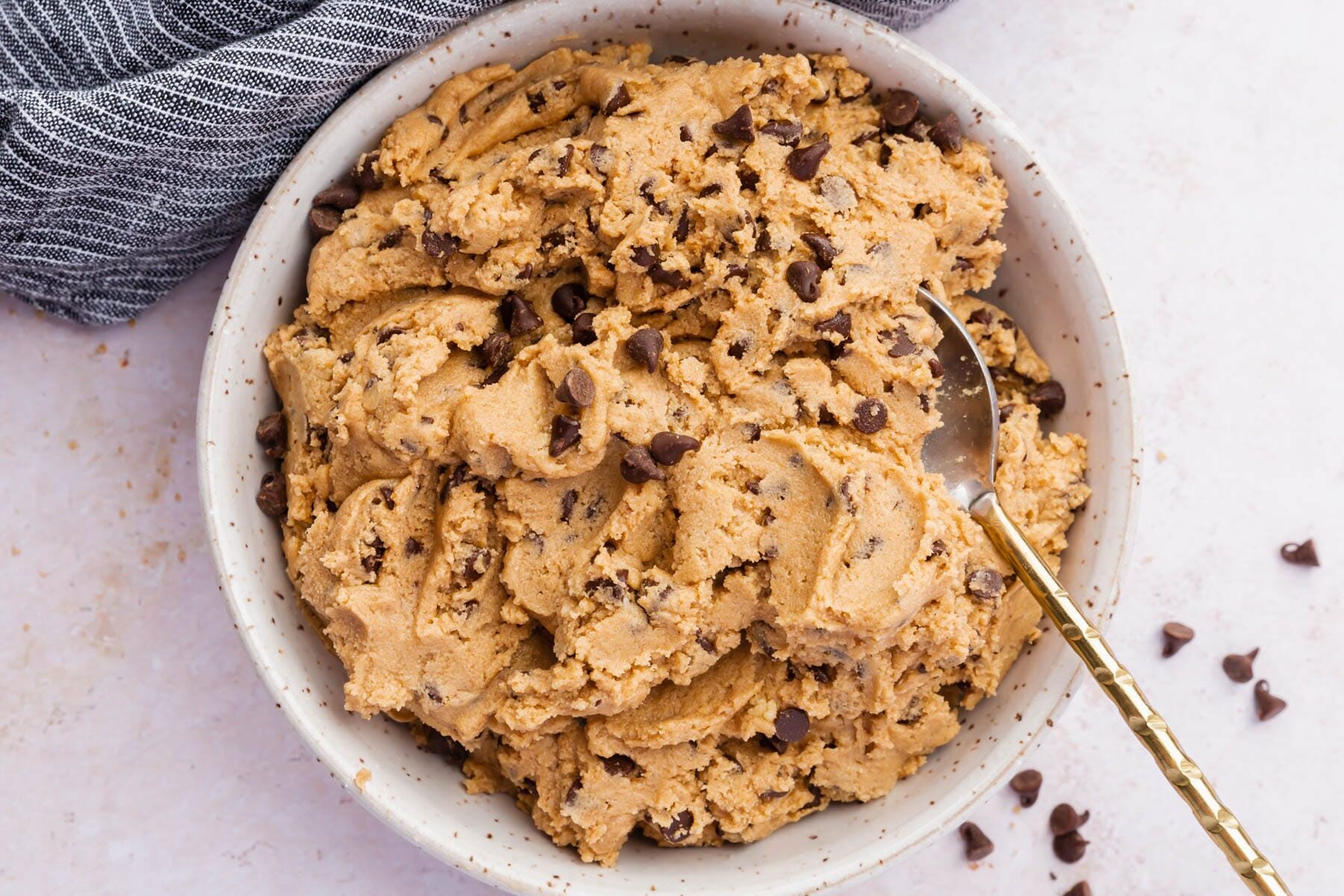 A bowl of gluten-free cookie dough with a spoon.