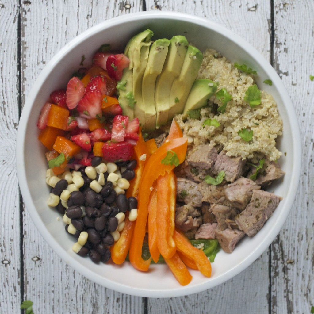 A white bowl with quinoa, steak, bell pepper, corn, black beans, and avocado. 