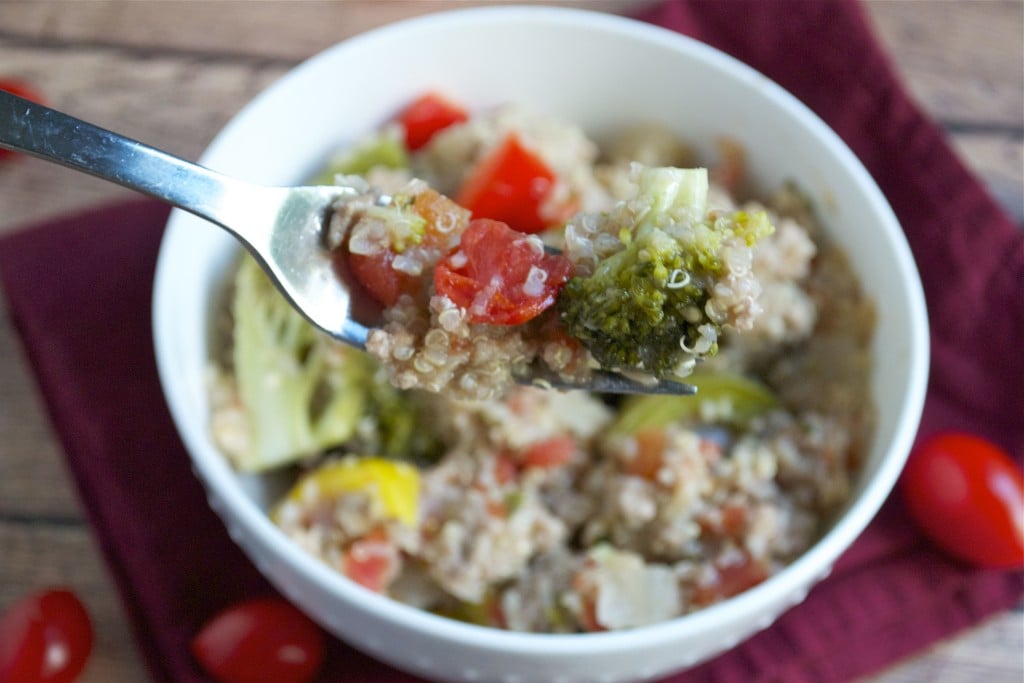 A fork full of quinoa, tomato, broccoli, and ground turkey over a bowl.