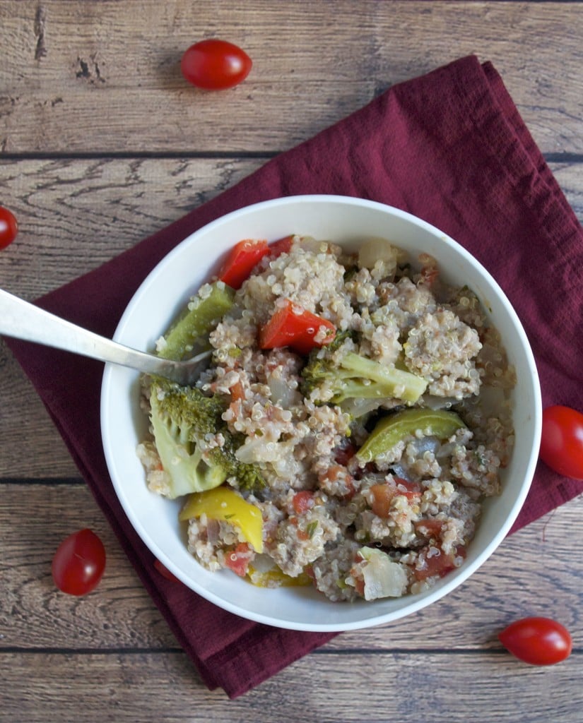 A bowl of quinoa, ground turkey, tomato, peppers, and broccoli with a fork in it.