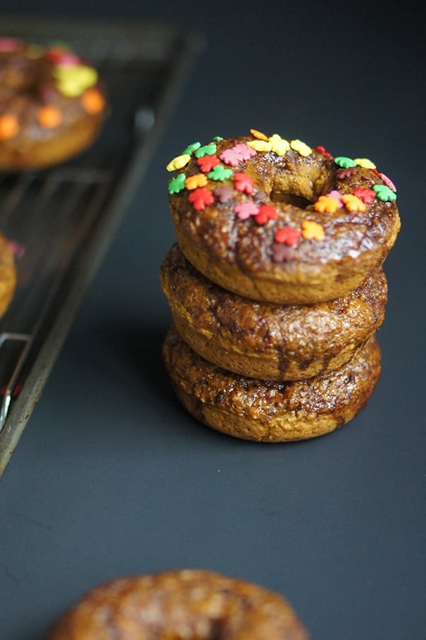 A stack of pumpkin donuts topped with leaf sprinkles.