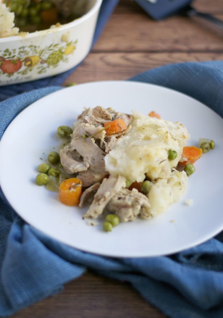 A plate of turkey shepherd's pie with peas and carrots. 