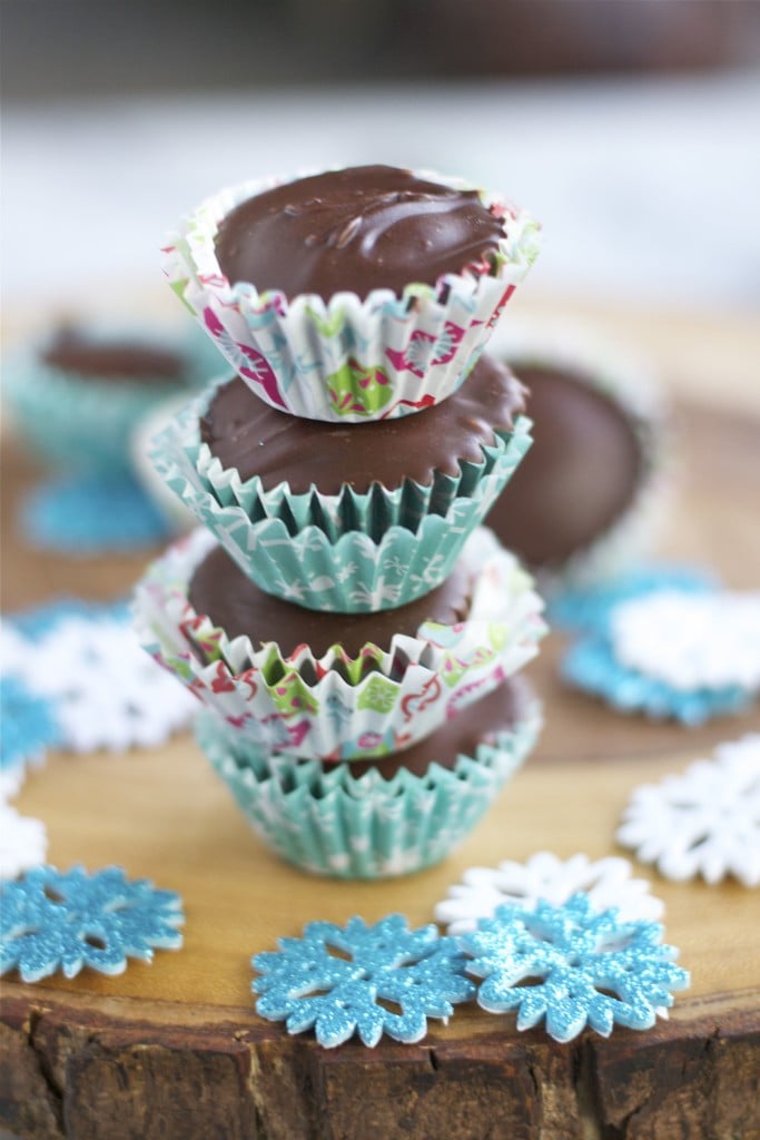 A stack of chocolate cookie dough cups in Christmas themed paper liners. 