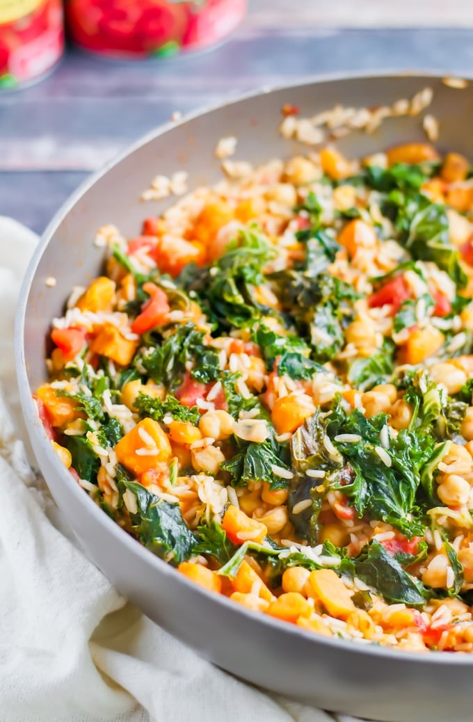 A skillet with kale, sweet potato, tomato, and rice. 