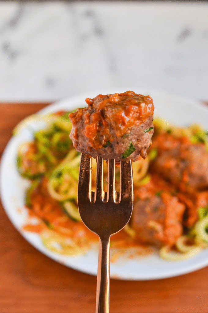A gif of a fork with a meatball on it that gets bitten in half.