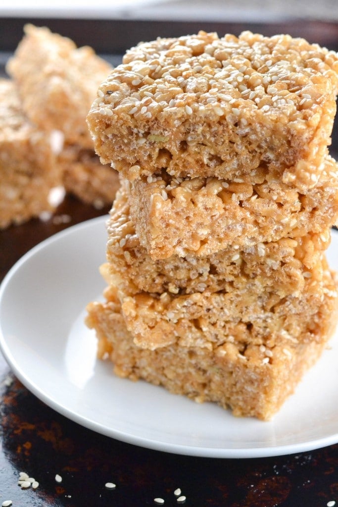 A stack of three tahini brown rice krispy treats topped with sesame seeds. 