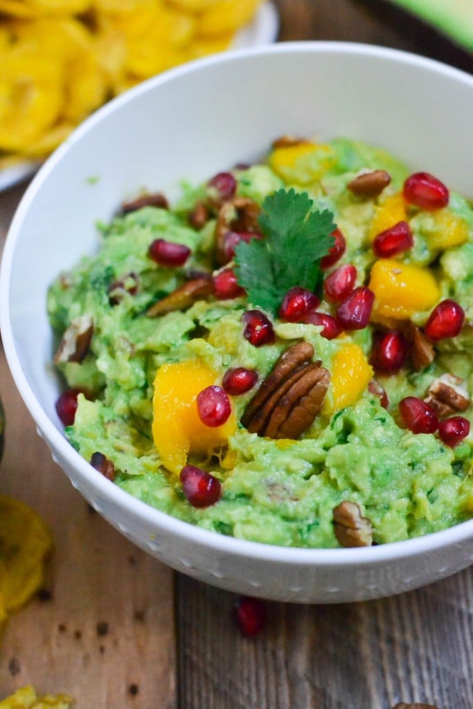 A bowl of Mango Pomegranate Pecan Guacamole topped with fresh cilantro. 