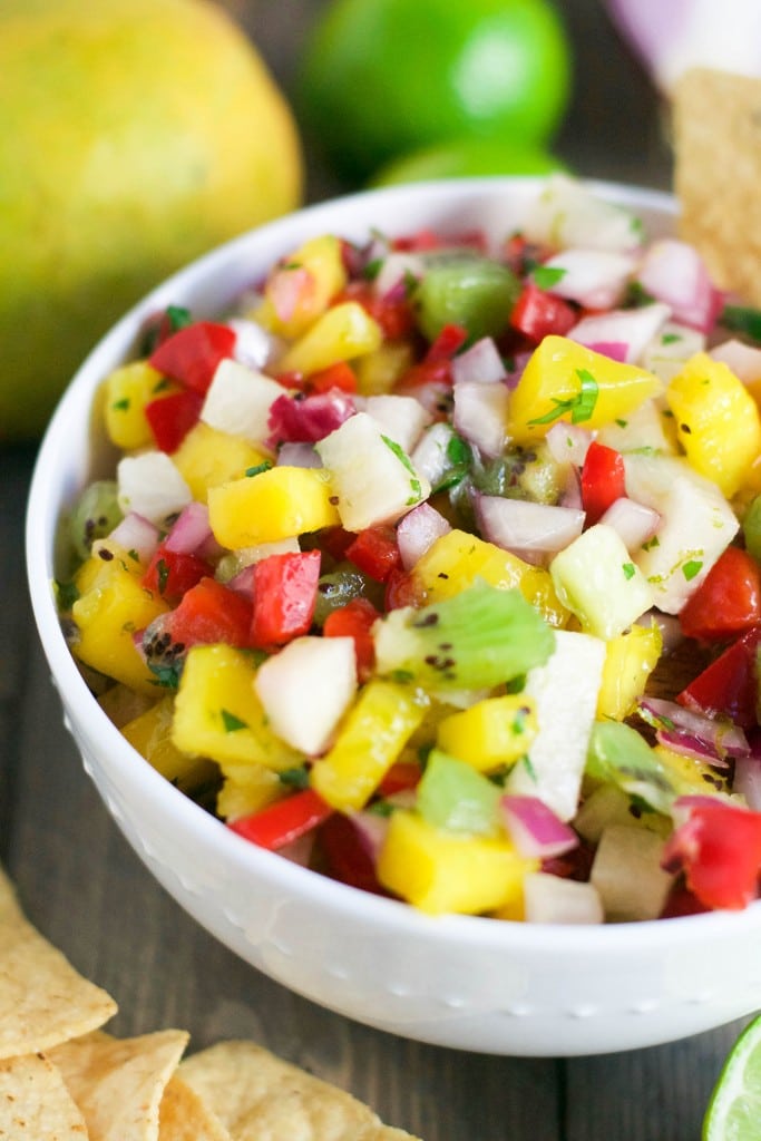 A bowl of kiwi mango jicama salsa with red bell peppers and cilantro. 