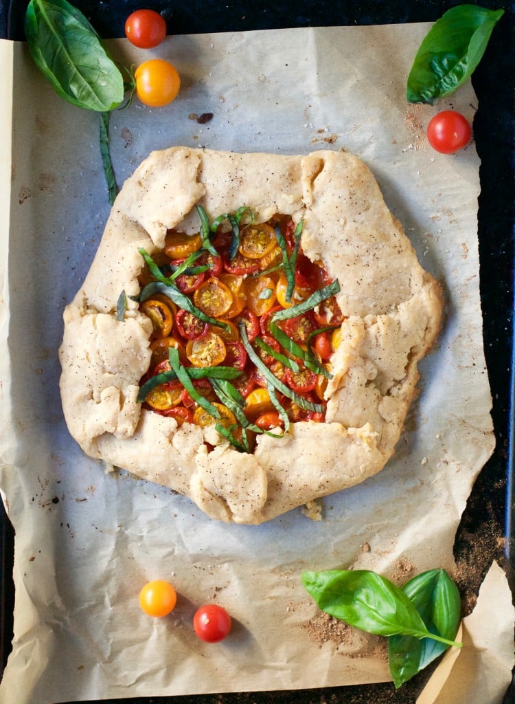 A tomato basil galette on a baking sheet lined with parchment paper. 