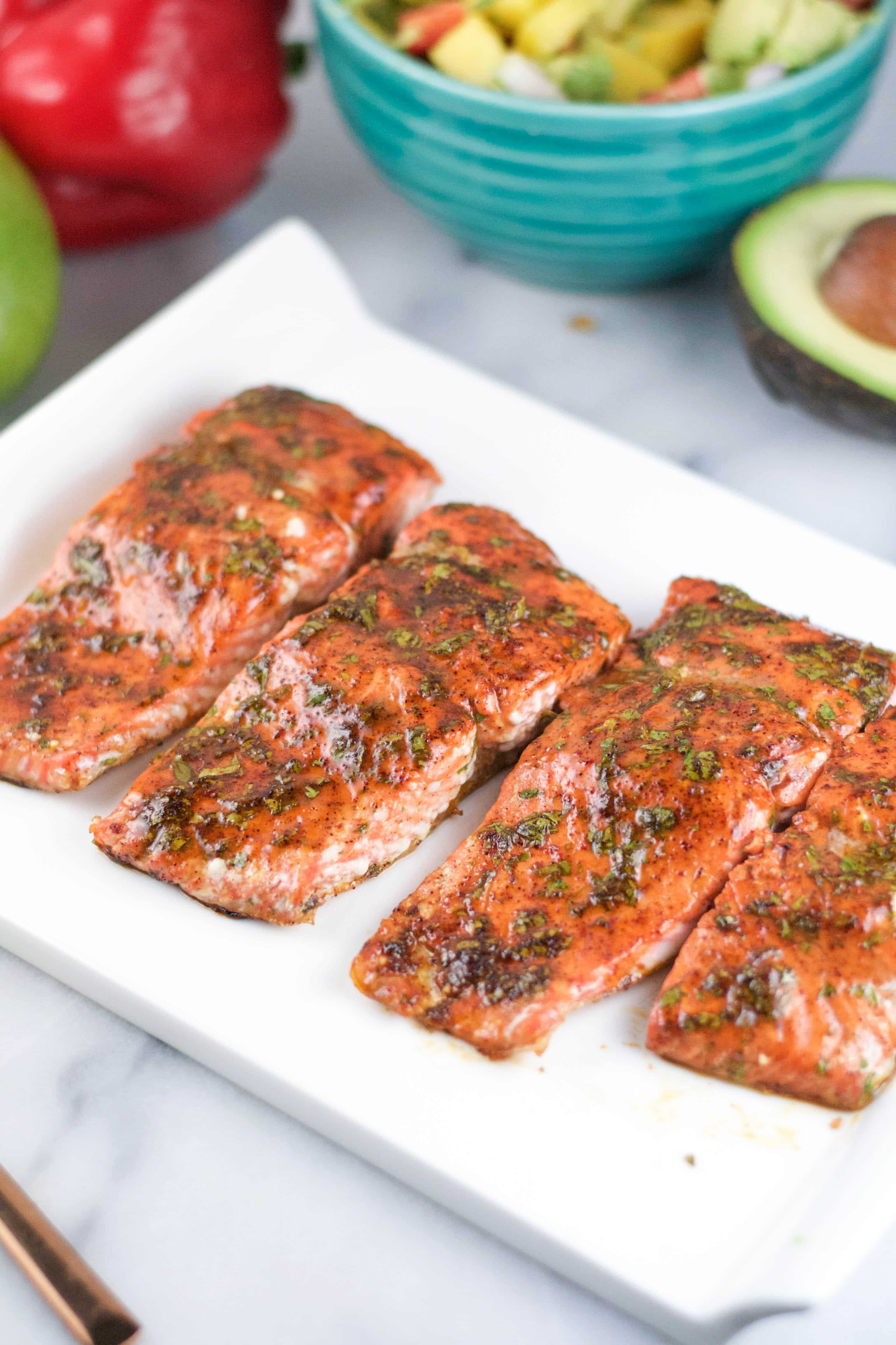 A platter of salmon portions with cilantro honey glaze on top. 